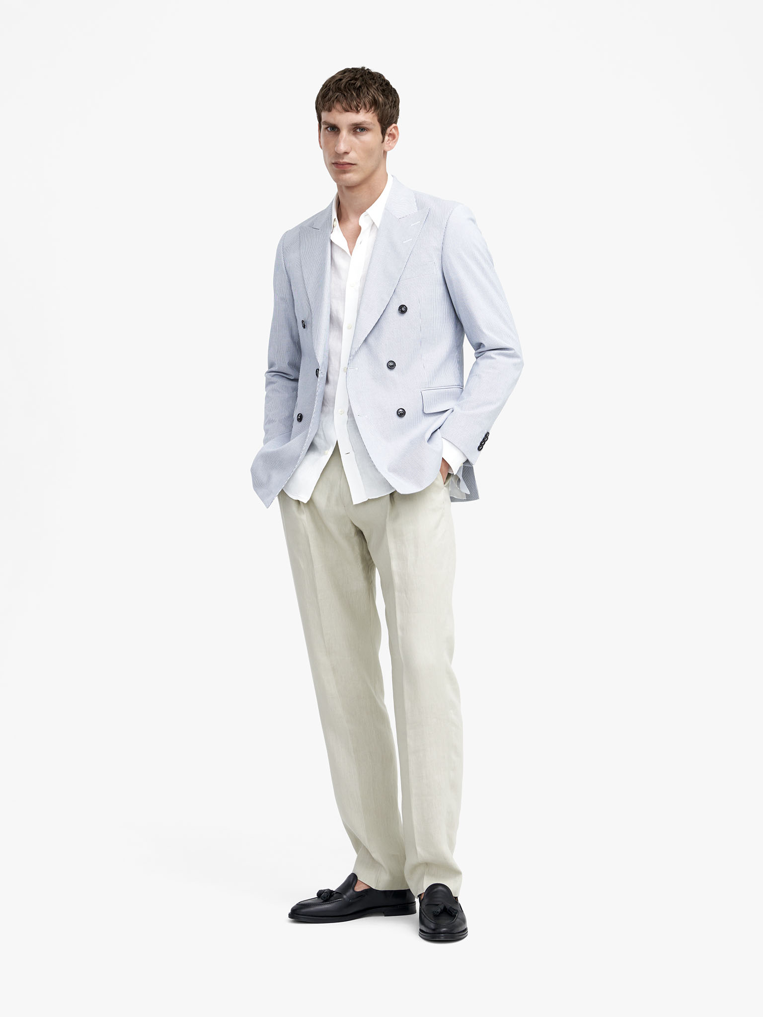 Man in light blue blazer and beige trousers